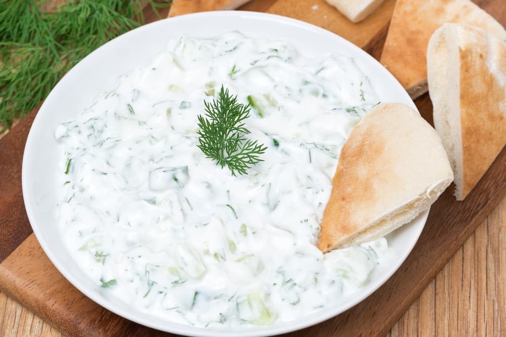 Bol de tzatziki grec traditionnel, sauce au yaourt, concombre et herbes fraîches.