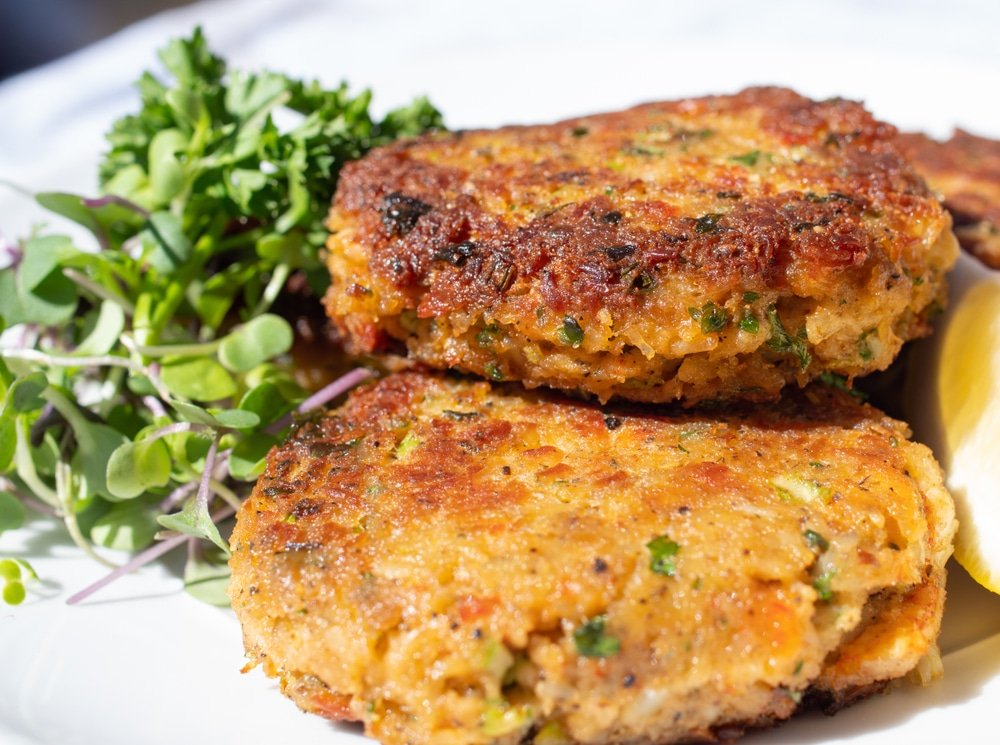 Crab cake dans une assiette accompagné de salade.