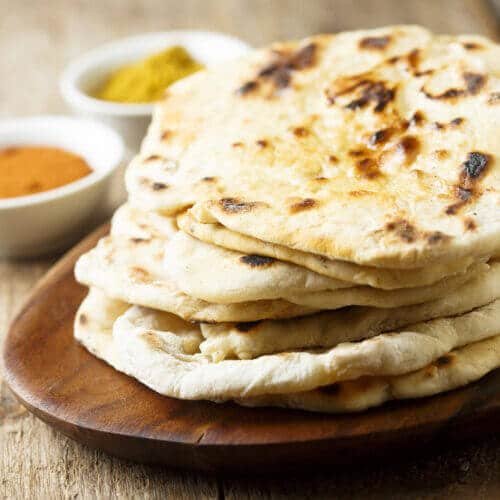 Naan empilés sur une assiette en bois