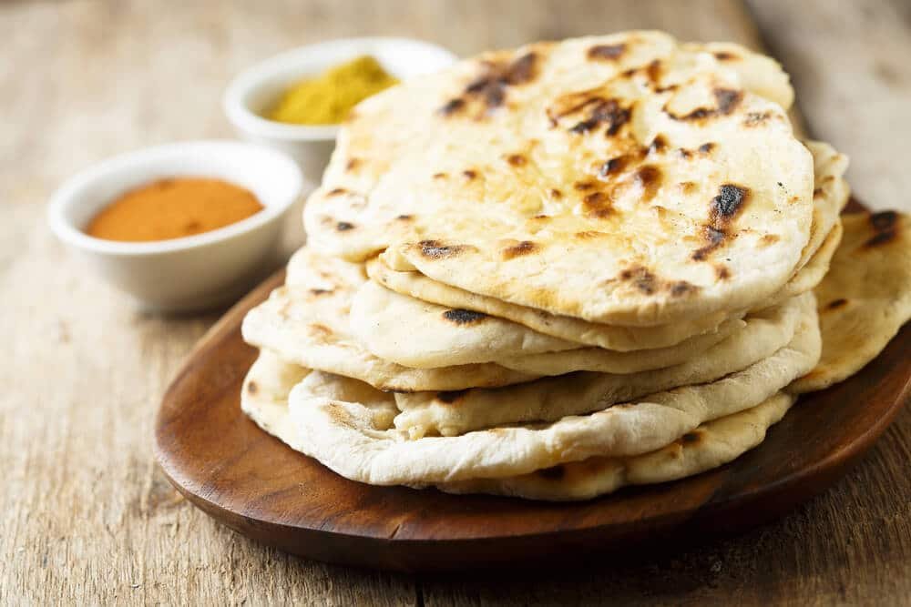 Naan empilés sur une assiette en bois