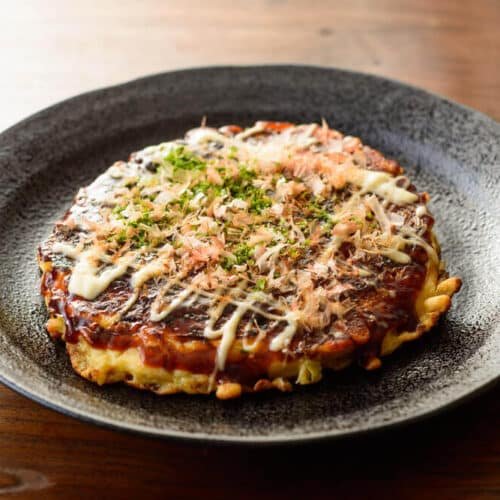 Okonomiyaki japonais servi avec de la mayonnaise et du katsuobushi