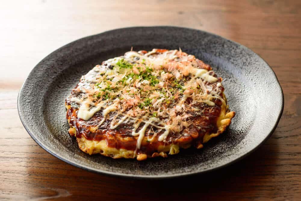 Okonomiyaki japonais servi avec de la mayonnaise et du katsuobushi