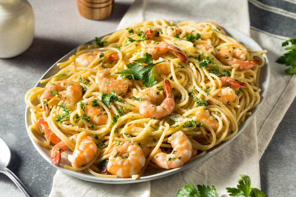 Plat de linguine aux crevettes saupoudré de parmesan et de persil