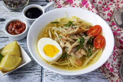 Soupe indonésienne soto ayam servie dans un bol avec du sambal